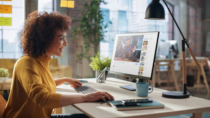 Middle Eastern Female Working in Creative Agency, Implementing Modern Business Strategy for Clients. Successful Specialist Using Computer, Watching Video about Cameras.