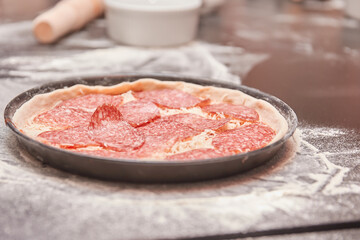 close up. pizza with salami prepared for baking.