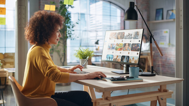 Middle Eastern Female Working in Creative Agency, Looking Through Social Media Trends for Marketing. Successful Specialist Using Computer with Video Streaming Platform Display