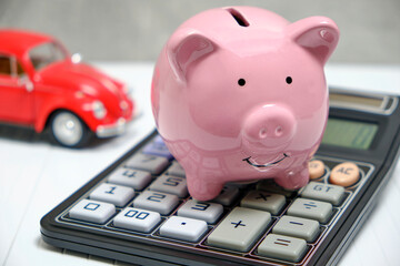 Piggy bank, calculator and car, concept spending and accumulating finances on car.