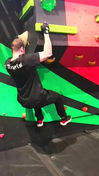 People bouldering on a climbing problem in a ninja warrior type experience