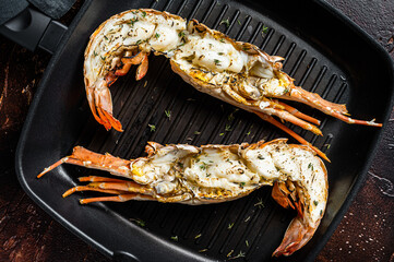 Delicious grilled and sliced Spiny lobster or sea crayfish. Dark background. Top view