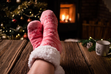 woman wearing pink wool winter socks in front of fireplace