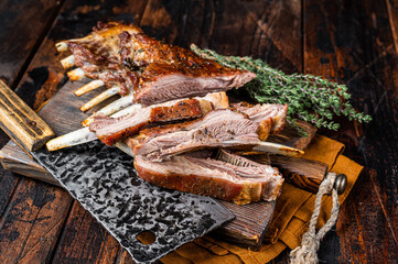 Roast lamb ribs, mutton spareribs, sliced meat on wooden board. Wooden background. Top view