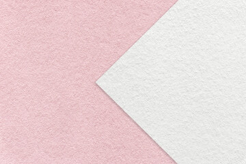 Texture of light pink paper background, half two colors with white arrow, macro. Structure of craft rose cardboard.