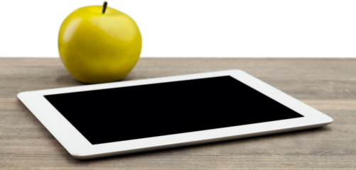 Green apple with digital table on wooden desk