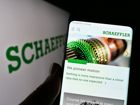 Stuttgart, Germany - 12-11-2022: Person holding smartphone with website of company Schaeffler Technologies AG Co. KG on screen in front of logo. Focus on center of phone display.