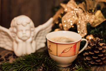 Christmas composition angel, cup of coffee on a dark wooden table