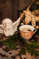 Christmas composition angel, cup of coffee on a dark wooden table