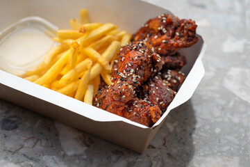 American cuisine. food delivery, takeaway food, paper containers with Fried chicken wings with tomato sauce
