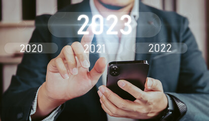 Business people touching 2023 number of the next year, concept go to new year 2023
