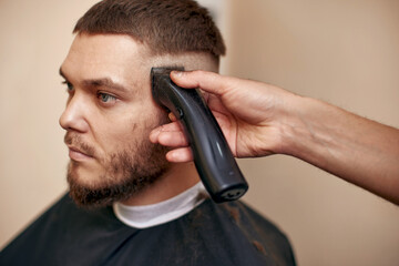 Barber shaving caucasian man in barber shop