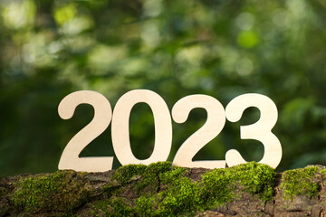 wooden numbers 2023 on a green background. happy new year 2023 background banner template. celebrate earth's day. happy New Year!
