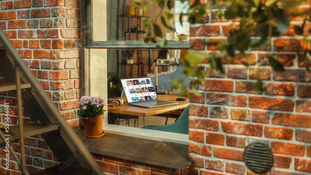 Poster Laptop Computer with Video Streaming Platform Display on Screen Standing on a Table in Stylish Living Room. View from Outside the Window of a Brooklyn-Style Brownstone Building. Work from Home Concept