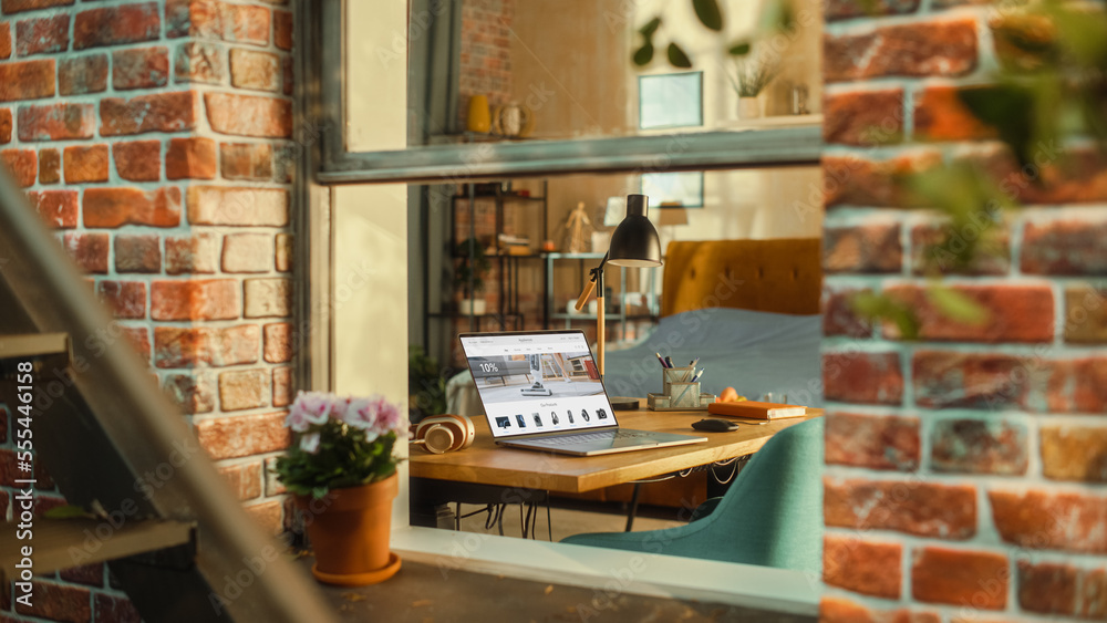 Aufkleber Laptop Computer with Online Shopping Website Display Standing on a Table in Stylish Living Room. View from Outside the Window of a Brooklyn-Style Brownstone Building. Work from Home Concept.