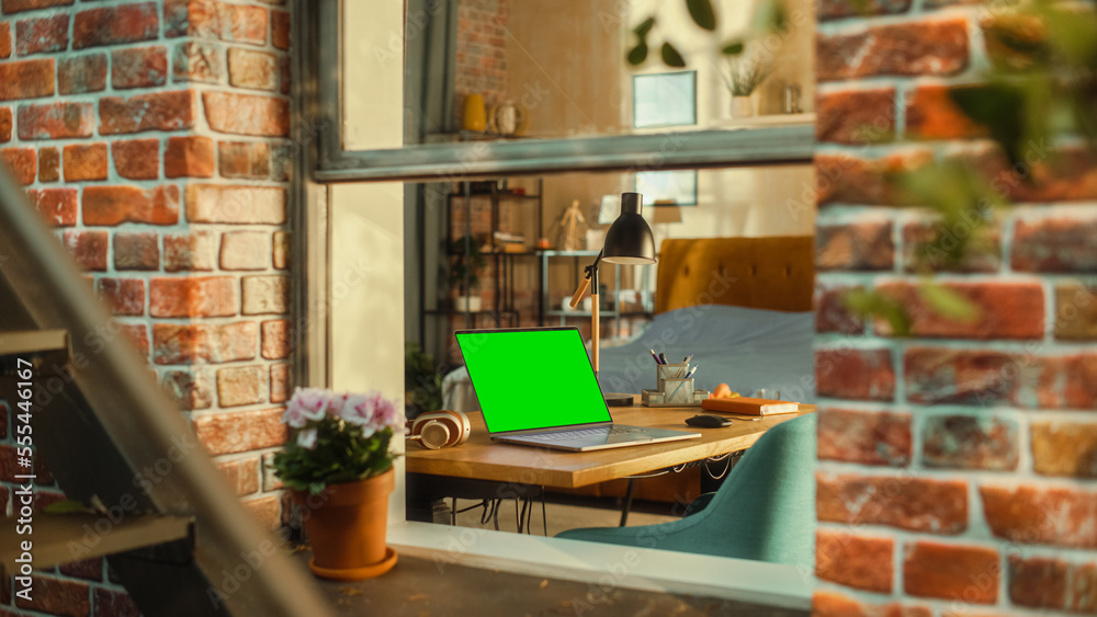 Poster Laptop Computer with Green Screen Mock Up Display Standing on a Table in Stylish Living Room. View from Outside the Window of a Brooklyn-Style Brownstone Multi-Storey Building. Work from Home Concept.