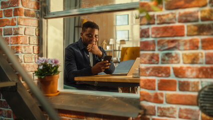Happy Young Black Male Sitting at Home, Connecting with Friends on Social Media, Using Online Apps...