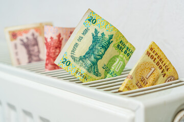 Moldovan money lei MDL on the radiator of the heating system, selective focus. Background