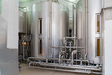 A stainless steel vat in the food industry at a brewery in the process of brewing beer. Background