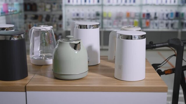 Department of consumer electronics in a shopping center. Showcase with smart wi-fi electric kettles.