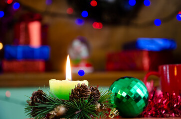 Close-up photo of candle shining on the festive table among colourful decoration at wonderful Christmas Day	
