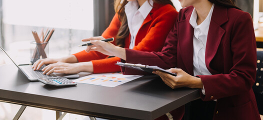 Businessman and team analyzing financial statement Finance task. with smart phone and laptop and...