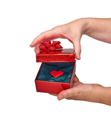 Woman opening gift box containing red heart on white background with red heart inside, isolated on white background and copy space. Concept of love, passion, romance, romantic, valentine.