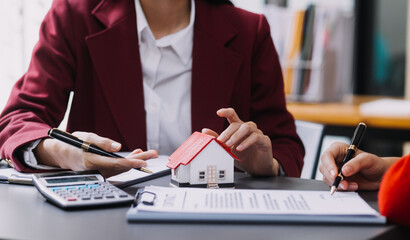 Discussion with a real estate agent, House model with agent and customer discussing for the contract to buy, get insurance or loan real estate or property.