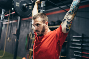 Obraz na płótnie Canvas Profile of a man lifting weight in a gym