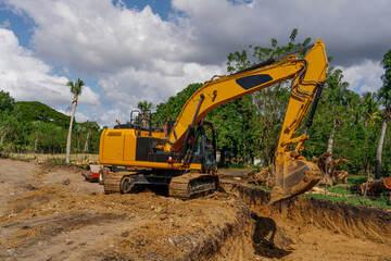 Fototapeta na wymiar Excavator at earthworks. The excavator prepares the site for the road.