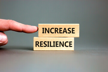 Increase resilience symbol. Concept word Increase resilience typed on wooden blocks. Beautiful grey table grey background. Businessman hand. Business and increase resilience concept. Copy space.