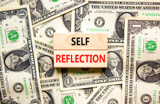 Self reflection symbol. Concept word Self reflection typed on wooden blocks. Beautiful background from dollar bills. Business psychological and self reflection concept. Copy space.