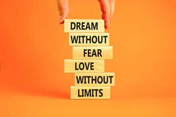 Dream and love symbol. Concept words Dream without fear love without limits on wooden blocks on a beautiful orange table orange background. Businessman hand. Dream and love without limits concept.