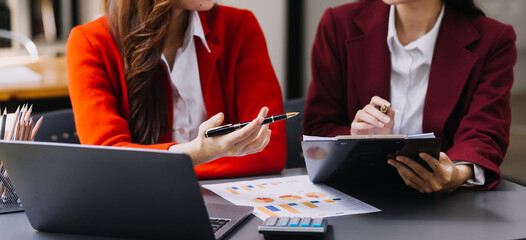 Businessman and team analyzing financial statement Finance task. with smart phone and laptop and...
