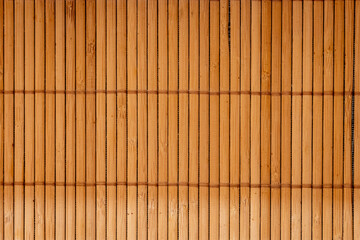 Brown bamboo texture background coming from natural bamboo straws. The oriental asian fencing has a beautiful yellow pattern, fence texture in daytime - obrazy, fototapety, plakaty