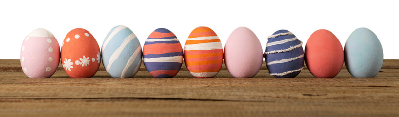 Row of colorful easter eggs on wooden desk