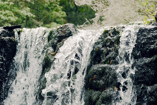 A magnificent waterfall at Bomarzo, Italy, inside a forest: strong flows of water going down from ancient stones.
