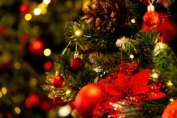 Close up of Christmas tree and balls. Bokeh garlands in the background. New Year and christmas concept with copy space. Wooden new year background, green tree, red berries