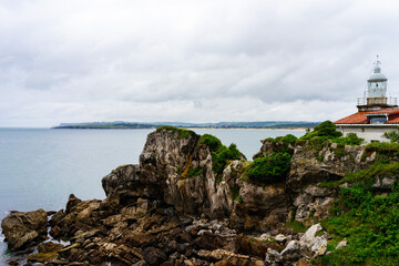 Fototapeta na wymiar Empty cliff with island in the background of the sea under cloudy day, Spain