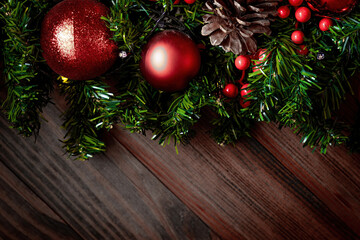 Fototapeta na wymiar Christmas decorations and fir branches on wooden board background with copy space. Wooden new year background, wooden surface, green tree, red berries