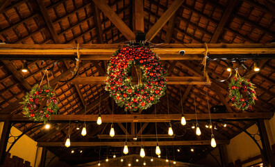 Obraz premium Close up of beautiful Christmas wreaths and balls. Bokeh garlands in the background. New Year and christmas concept with copy space, green tree, red berries