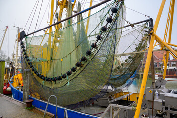 Net on a colorful shrimp fishing boat in the historic harbor of Neuharlingersiel