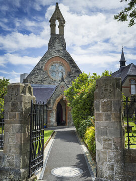 Open gate and path leading to the entrance of a stone church; Londonderry, Ireland