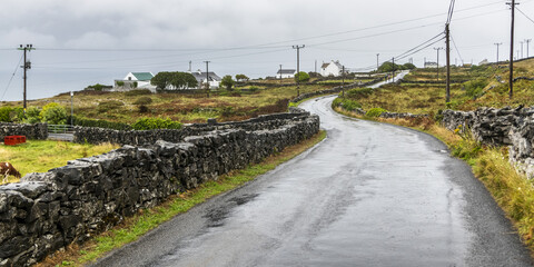 A wet road in an Irish village on the West Coast of Ireland at the mouth of Galway Bay, Inishmore, Aran Islands; Kilronan, County Galway, Ireland