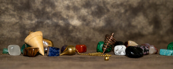 petits pendules de divination dans un décor avec petites pierres semi précieuses