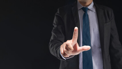 Businessman hand touching virtual screen on black background