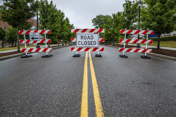 Double yellow line on a street with traffic barriers and 'Road Closed' sign; Connecticut, United States of America
