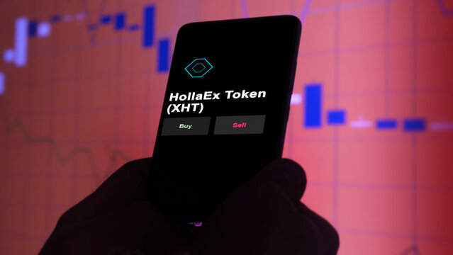 November 3th 2022, Roma. An investor's analyzing the HollaEx Token (XHT) coin on screen. A phone shows the crypto's prices to invest