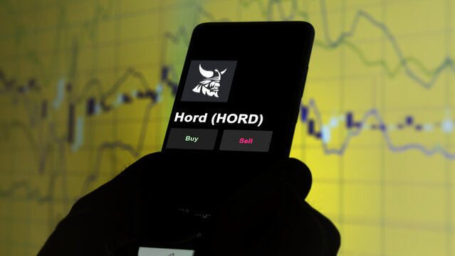 November 3th 2022, Roma. An investor's analyzing the Hord (HORD) coin on screen. A phone shows the crypto's prices to invest hord crypto