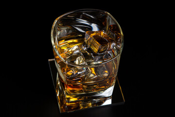 Glass of whiskey with ice on a black background. Strong alcoholic drink